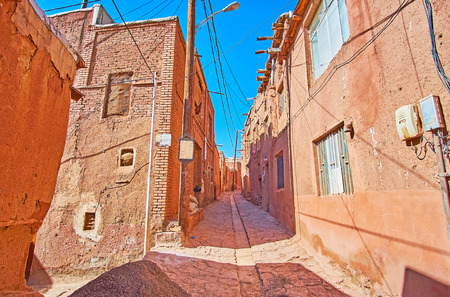 Walk the old narrow street of the oldest Iranian village, located in Karkas mountains and famous for its unusual reddish color of edifices, Abyaneh.の写真素材
