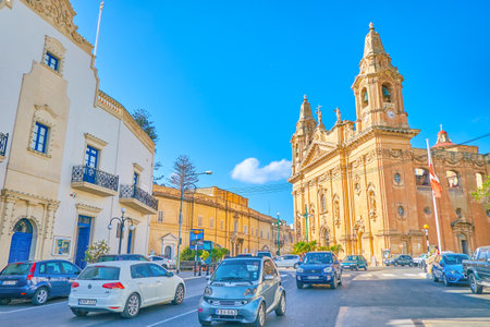 NAXXAR, MALTA - JUNE 14, 2018: The traffic in the center of the town with a huge Parish Church on the background, on June 14 in Naxxar.のeditorial素材