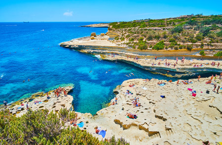 MARSAXLOKK, MALTA - JUNE 18, 2018: Fantastic rocky landscape of the limestone beach of St Peter's Pool, located on Delimara peninsula, on June 18 in Marsaxlokk.のeditorial素材