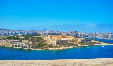 The view on the medieval star fort on Manoel Island and the modern coast of Gzira and Sliema resorts behind it from the top of St Michael's Bastion of Valletta fortress, Malta.のeditorial素材