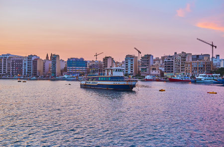 SLIEMA, MALTA - JUNE 18, 2018: The modern coast of Sliema, facing Valletta Northern Harbour, with ships and boats along the shore, on June 18 in Sliema.のeditorial素材