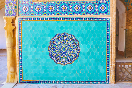 The wall of Jameh Mosque is decorated with ornate Islamic pattern, created of hexagonal azure tiles and floral rosette in the middle of the panel, Yazd, Iran.の写真素材