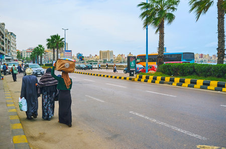 ALEXANDRIA, EGYPT - DECEMBER 19, 2017: Chaotic pedestrian movement along the road in Corniche Avenue, on December 19 in Alexandria.のeditorial素材