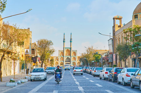 YAZD, IRAN - OCTOBER 18, 2017: Fast traffic in Qiyam street with mullah (Islamic cleric), riding on...