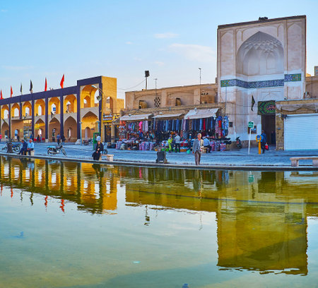 YAZD, IRAN - OCTOBER 18, 2017: The fountain in Amir Chakhmaq square reflects the stalls of the tourist bazaar, arched gallery and the portal of Dahouk mosque, on October 18 in Yazdのeditorial素材