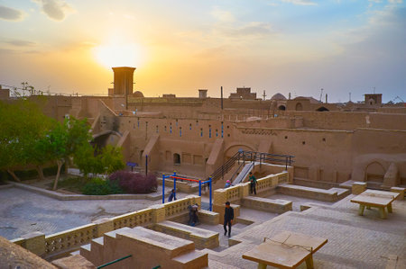 YAZD, IRAN - OCTOBER 18, 2017: The colorful sunset over the medieval Fahadan district with preserved adobe mansions, tiny garden and playground among them, on October 18 in Yazdのeditorial素材