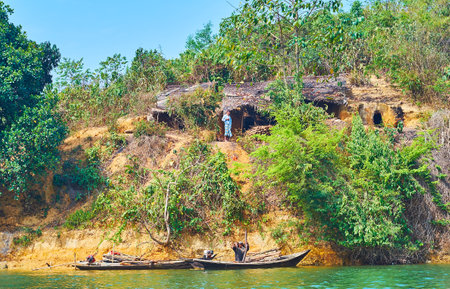 CHAUNG THA, MYANMAR - MARCH 1, 2018: The hill at the bank of Kangy river with dugout shelters of local villagers, on March 1 in Chaung Tha.のeditorial素材