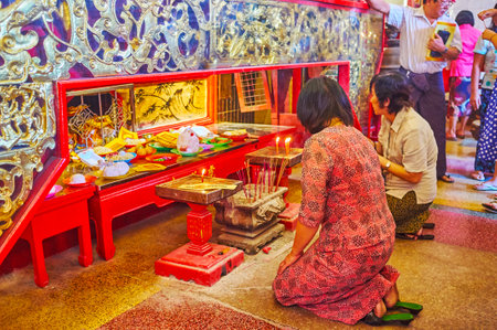YANGON, MYANMAR - FEBRUARY 17, 2018: People pray in main shrine of Kheng Hock Keong (Qingfu) Temple...