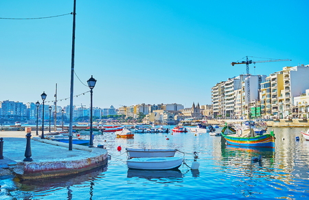 St Julian's seaside promenade is the nice place to relax, walking along the shore, and enjoy the lazy bobbing boats, Spinola Bay, Malta.の写真素材