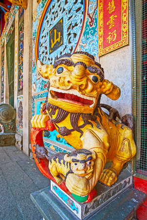 YANGON, MYANMAR - FEBRUARY 17, 2018: The scenic statue of colorful Royal guardian lion (foo dog) at the entrance to historic Long Shan Tang Clan Temple, on February 17 in Yangon.のeditorial素材