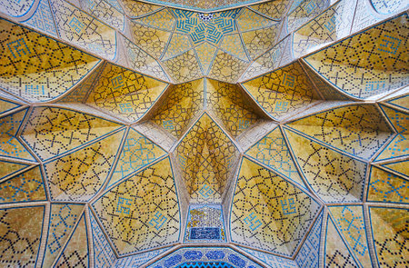 The close-up of the muqarnas (honeycomb) arch of the West portal of Jameh mosque, the brick cells are covered with intricate mosaic patterns, Isfahan, Iran.のeditorial素材