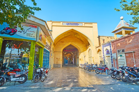 ISFAHAN, IRAN - OCTOBER 21, 2017: The brick portal with traditional tiling is the entrance to Hassan Abad Bazaar - the covered alleyway, stretching to the Naqsh-e Jahan square, on October 21 in Isfahan.のeditorial素材