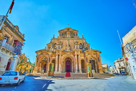 The scenic facade of the Parish Church of St Nicholas of Bari, decorated with garlands and lanterns due to the Feast of St Nicholas - the patron Saint of Siggiewi town, Malta.のeditorial素材