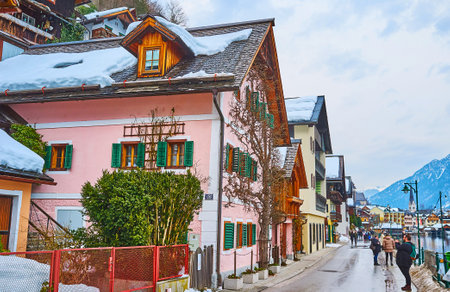 HALLSTATT, AUSTRIA - FEBRUARY 21, 2019: People walk along Seestrasse - embankment of the town, facing Hallstatter see (lake), on February 21 in Hallstatt.のeditorial素材