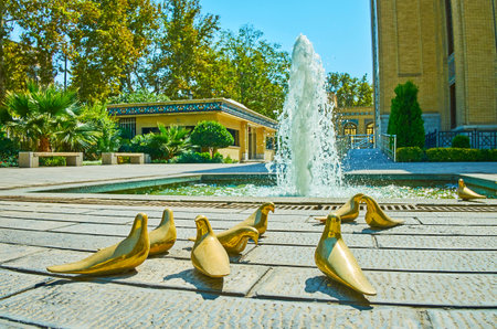TEHRAN, IRAN - OCTOBER 25, 2017: The sculptural composition of gilded pigeons at the fountain in garden of  Malek National Museum and Library, Bagh-e Melli cultural-historical centerのeditorial素材