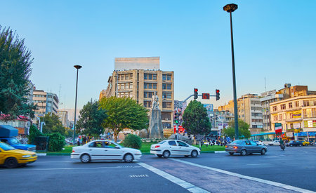 TEHRAN, IRAN - OCTOBER 10, 2017: The fast traffic in Ferdowsi Square with a view on green park and...