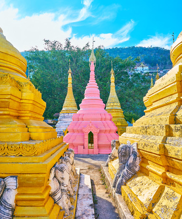 The bright pink stupa among the golden pagodas of Nget Pyaw Taw Paya, Pindaya, Myanmar.の写真素材
