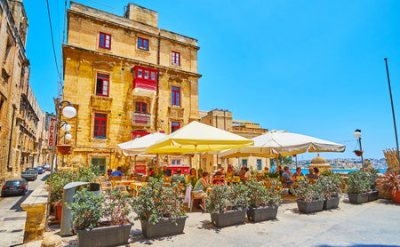 VALLETTA, MALTA - JUNE 19, 2018: The cozy outdoor terrace of the restaurant in St Ursula street of the old town, surrounded with plants in pots, on June 19 in Vallettaのeditorial素材