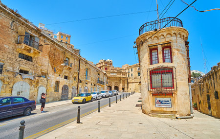 VALLETTA, MALTA - JUNE 19, 2018: Historic Liesse street is lined with old warehouses; the scenic Victoria Gate of Valletta fortifications is seen on background, on June 19 in Vallettaのeditorial素材
