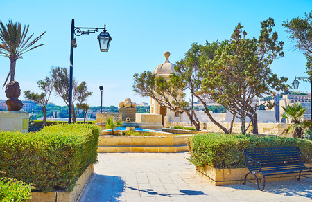 The scenic Gardjola Gardens, located on the upper level of fortress wall, decorated with stone cannon balls and trimmed bushes, Senglea, Malta.の写真素材