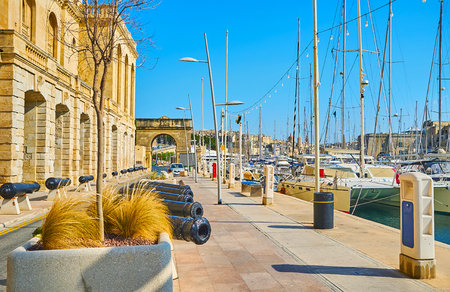 The old Xatt Il-Forn promenade is decorated with old cannons, standing along the wall of Maritime museum of Birgu, Malta.の写真素材