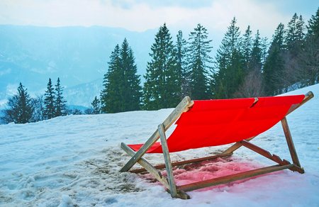 The red sun bed in snow on the slope of Mount Katrin, Bad Ischl, Salzkammergut, Austriaの写真素材