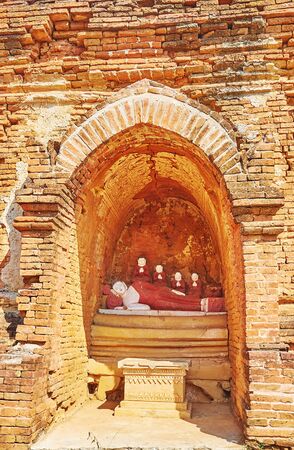 The small niche in ancient pagoda with statue of Reclining Buddha and disciples around him, Bagan, Myanmarの写真素材