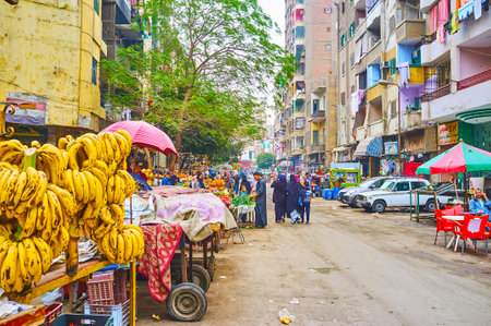 CAIRO, EGYPT - DECEMBER 22, 2017: The wide dusty street of Souq As Sebaeyin bazaar with numerous tiny stalls, market carts with fresh fruits and vegetables, on December 22 in Cairo.のeditorial素材