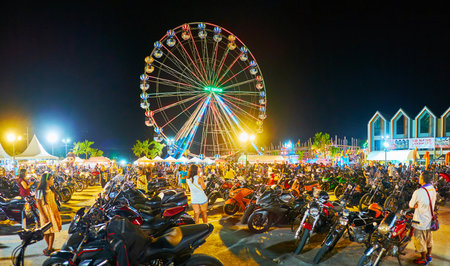 AO NANG, THAILAND - APRIL 27, 2019: The view on hundreds of parked motorcycles of Ao Nang Bike Week participants; ferris wheel and night market stalls are seen on background, on April 27 in Ao Nangのeditorial素材