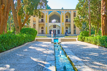 KASHAN, IRAN - OCTOBER 23, 2017: Walk along green shady alley of oldest in country Fin Garden with a view on Kushak - the scenic pool house, decorated with tiled patterns, on October 23 in Kashan.のeditorial素材