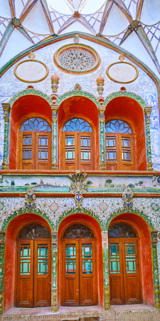 KASHAN, IRAN - OCTOBER 23, 2017: The wall with arched doors and windows, surrounded by fine floral patterns, Borujerdi Historical House, on October 23 in Kashan.のeditorial素材