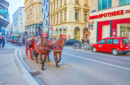 VIENNA, AUSTRIA - FEBRUARY 18, 2019: The horse drawn carriages are the popular tourist transport in old town, that ride slow among main landmarks, on February 18 in Vienna.のeditorial素材