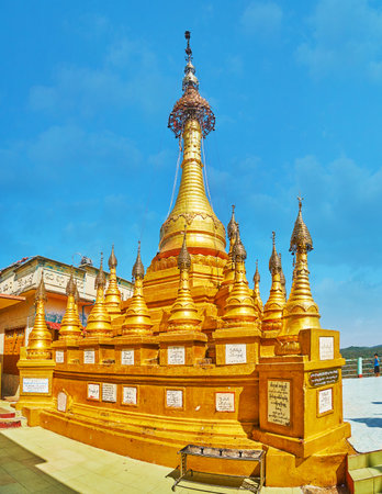 POPA, MYANMAR - FEBRUARY 26, 2018:  The carved golden pagoda in Popa Taung Kalat monastery with many small stupas around the main one, decorated with ringing hti umbrella on the top, on February 26 in Popaのeditorial素材