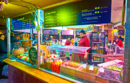 VIENNA, AUSTRIA - FEBRUARY 18, 2019: The merchant waits clients at the food stall of winter fain on Rathausplatz, on February 18 in Viennaのeditorial素材