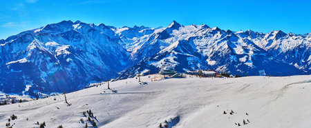 Panorama of Schmittenhohe mount ski resort with chairlifts, cableways, fine ski pistes, numerous snowshoeing routes and rocky Alps on background, Zell am See, Austriaのeditorial素材