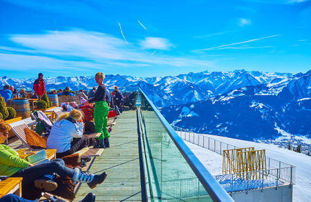 ZELL AM SEE, AUSTRIA - FEBRUARY 28, 2019: Crowded outdoor terrace of lounge Panorama restaurant on top of Schmitten mount with many sportsmen, relaxing here after the downhill, on February 28 in Zell Am See.のeditorial素材