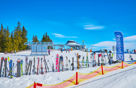 ZELL AM SEE, AUSTRIA - FEBRUARY 28, 2019: The sportsmen leaved ski and snowboard gear in snow around the chair lift station in Areitalm Alpine Meadow, on February 28 in Zell Am See.のeditorial素材