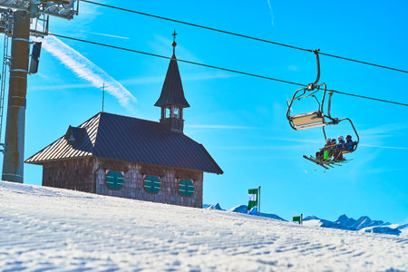 The fast riding ski lift in front of the Elisabeth chapel, located on the top of Schmitten mountain, Zell Am See resort, Austriaのeditorial素材