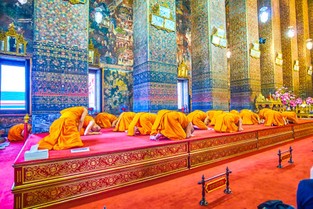 BANGKOK, THAILAND - APRIL 22, 2019: The monks of Wat Pho temple in Ordination Hall in Phra Ubosot shrine, kneeling during the pray, on April 22 in Bangkokのeditorial素材