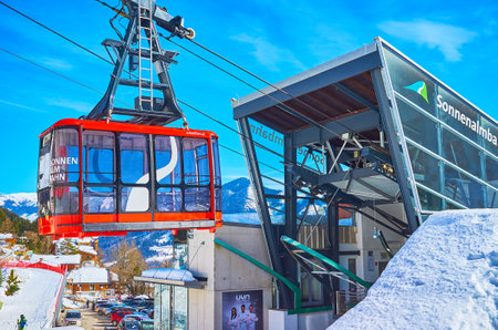 ZELL AM SEE, AUSTRIA - FEBRUARY 28, 2019: The bright red cabin of Sonnenalmbahn cable car arrives to its lower station, on February 28 in Zell Am Seeのeditorial素材