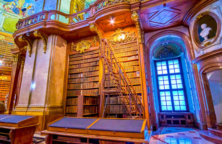 VIENNA, AUSTRIA - MARCH 2, 2019: The vintage wooden bookshelves with old rare books and high rolling ladder of National Library of Hofburg Palace, on March 2 in Viennaのeditorial素材