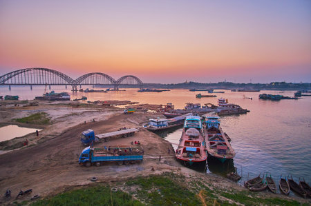 MANDALAY, MYANMAR - FEBRUARY 22, 2018: The cargo port on Irrawaddy river with a view on twilight...