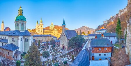 The panoramic view from the catacombs in the rock of the courtyard of St Peter cemetery with  its chapels and huge Cathedral on the background, Salzburg, Austriaの写真素材
