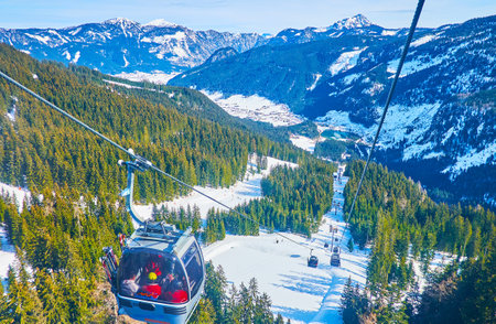 GOSAU, AUSTRIA - FEBRUARY 26, 2019: Fantastic journey on Panorama Jet Zwieselalm cable car, riding over the steep slope, covered with lush spruce forests and curved ski runs, on February 26 in Gosauのeditorial素材
