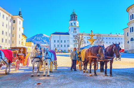 SALZBURG, AUSTRIA - FEBRUARY 27, 2019: The horse drawn carriages, are the historical transport of Salzburg, nowadays are the popular tourist leisure transport in old town, on February 27 in Salzburgのeditorial素材