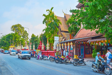 CHIANG MAI, THAILAND - MAY 2, 2019: The road in front of Wat Phantao Temple with line of parked tuk tuks, mopeds and driving cars, on May 2 in Chiang Maiのeditorial素材