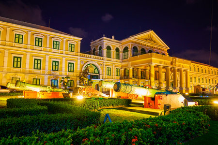 BANGKOK, THAILAND - APRIL 22, 2019: The facade of the Ministry of Defense building with medieval cannons in the garden, on April 22 in Bangkokのeditorial素材