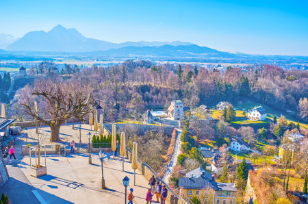 SALZBURG, AUSTRIA - FEBRUARY 27, 2019: The panoramic terrace of Salzburg Castle attracts tourists to enjoy the cityscape, lush greenery of Monchsberg hill and old housing, on February 27 in Salzburg.のeditorial素材