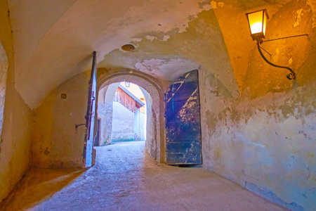SALZBURG, AUSTRIA - FEBRUARY 27, 2019: The stone corridor with shabby walls and old wooden doors leading to the courtyard of Hohensalzburg Castle, on February 27 in Salzburgのeditorial素材