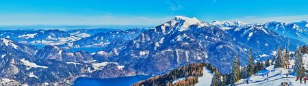 Alpine panorama from the top of Zwolferhorn mount with sharp peaks, rocky slopes, winter forests, blue Wolfgangsee and Mondsee lakes, St Gilden, Salzkammergut, Austriaの写真素材